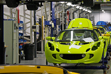 Car manufacturing production line with brightly coloured bodies of vehicles 