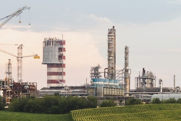 image of fertilizer factory with green field in front against a sunrise sky