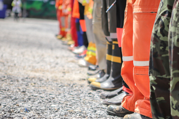 Legs of various emergency workers in uniform and PPE