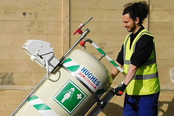 Employee in high vis vest moving Hughes mobile safety shower unit