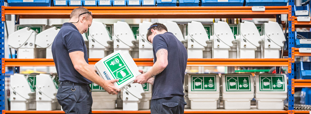 Two workers looking at an eye wash shell