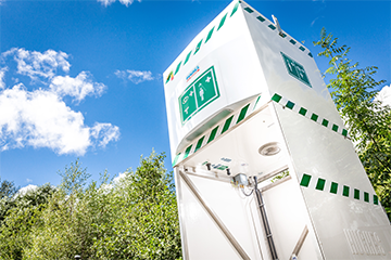 Hughes emergency tank-fed safety shower shown against blue skies and clouds