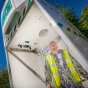 Hughes emergency tank shower shown in use by worker in high vis
