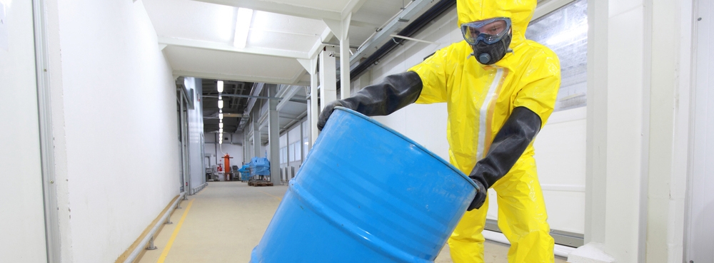 Worker in PPE handling a containment barrel