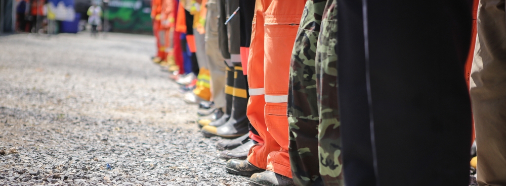 Legs of various emergency workers in uniform and PPE
