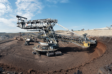 Mining excavator Mining excavator on worksite with blue sky in background